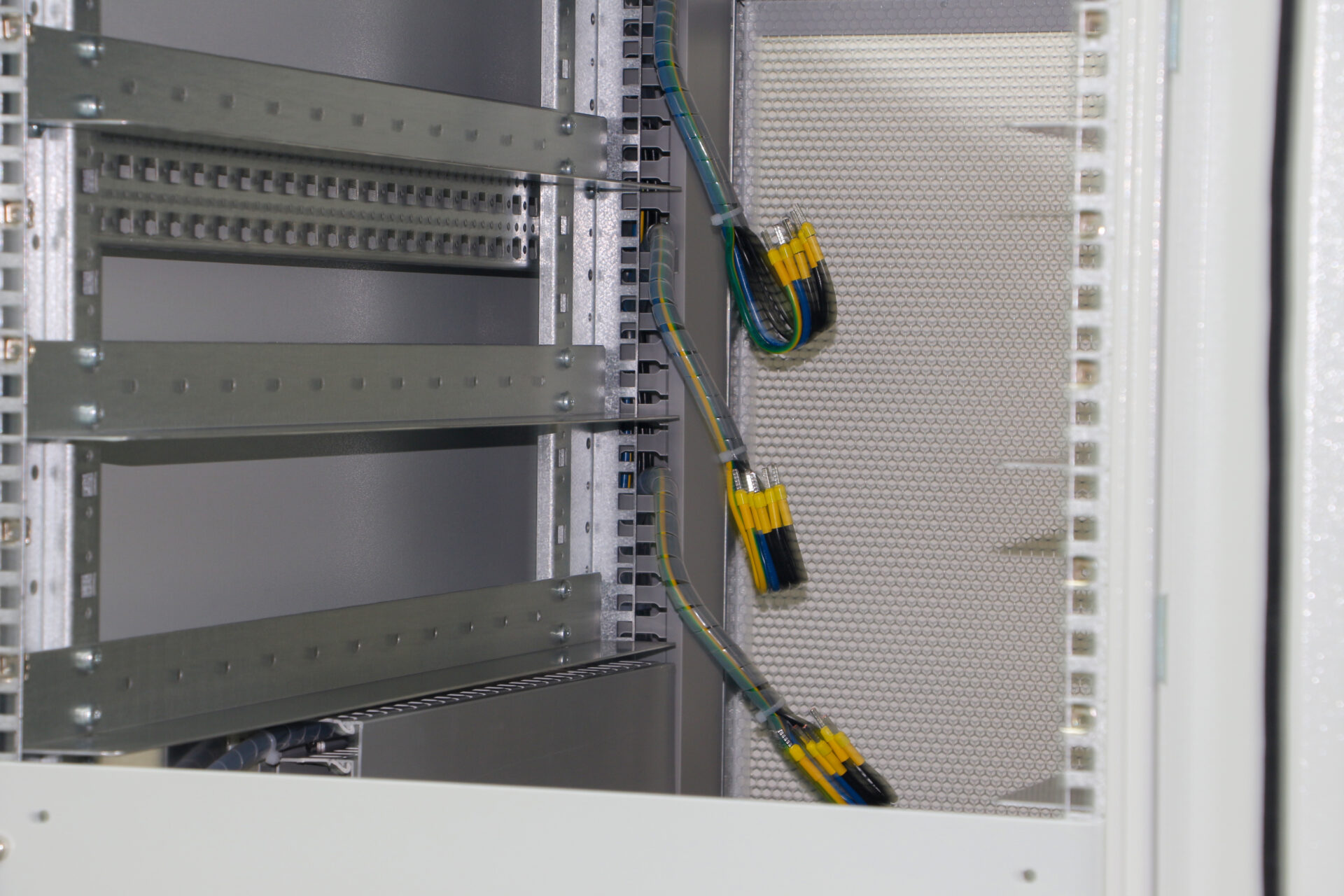 Die Stahlstruktur bietet Vibrationsdämpfung und EMI-Abschirmung, während Aluminiumkomponenten als passive Kühlkörper in einer Fabrikautomatisierungsumgebung wirken.
