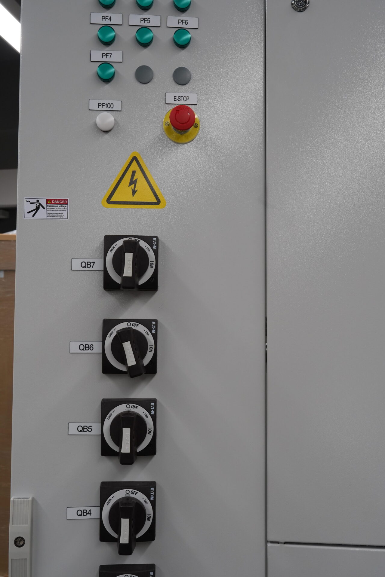 Nahaufnahme des Bedienbereichs des 48U Power Cabinet mit beleuchtetem Not-Halt-Taster und Sicherheitstürverriegelung. Demonstriert die Integration des vorverdrahteten Energieverteilerschranks mit Fernsteuerungsfunktion und die Einhaltung europäischer Sicherheitsrichtlinien